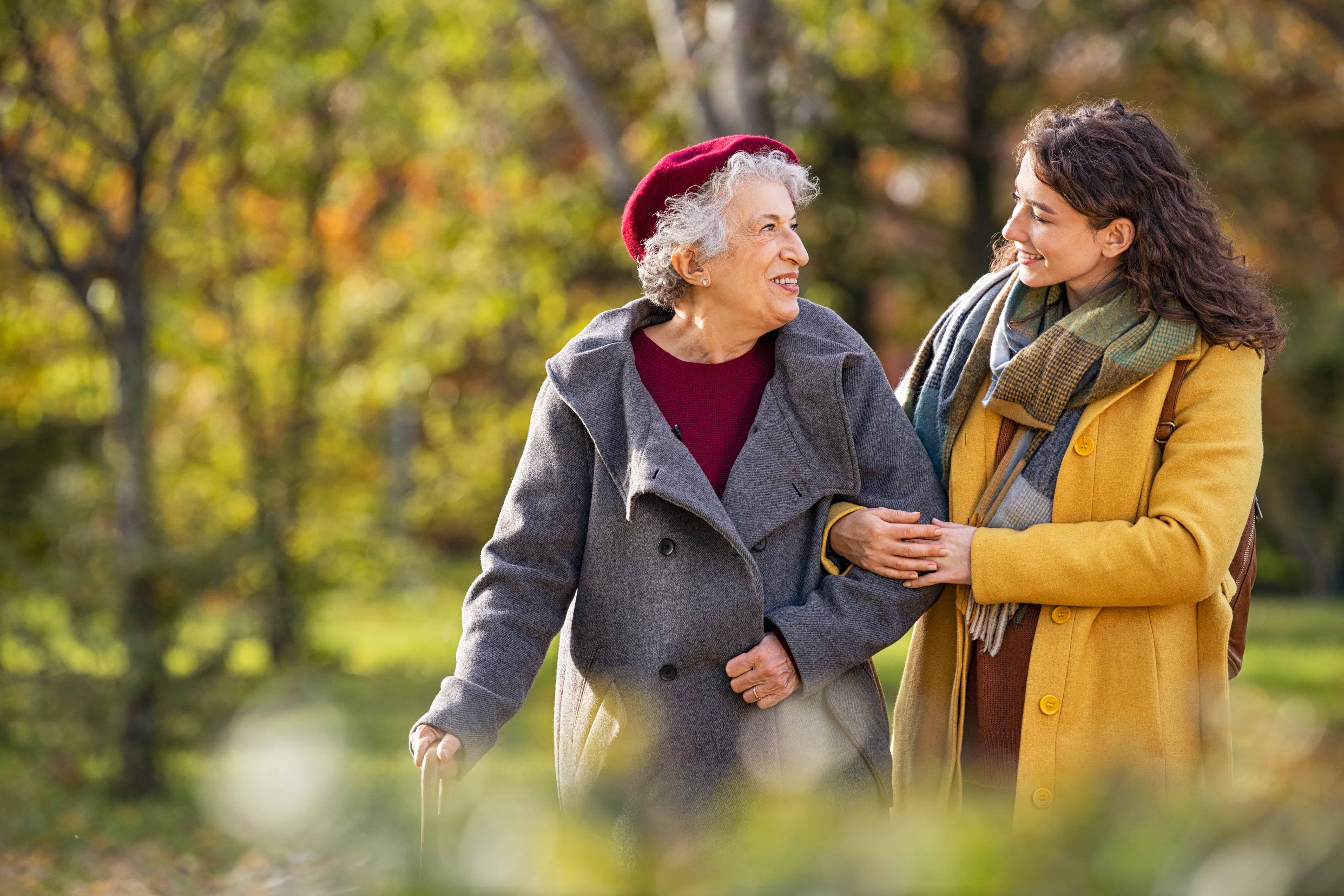 a female caregiver performs companionship by walking with her female client outside