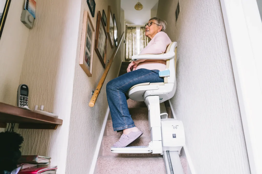 Senior woman riding automatic stairlift in her home