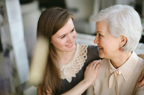 a senior woman smiles at their in home caregiver