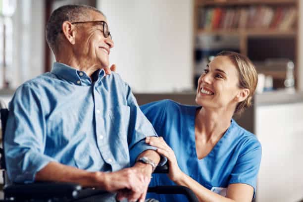 in home caregiver smiles at her senior client