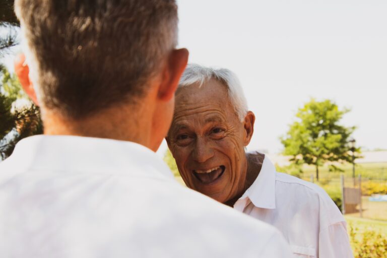 an elderly man smiles at their son