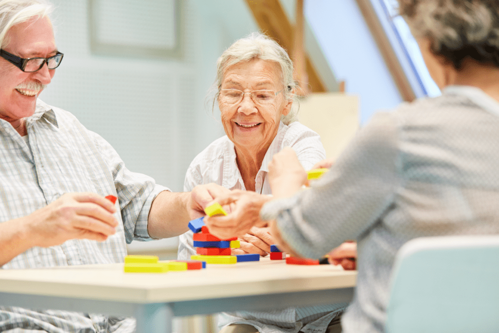three seniors happily work together on a puzzle