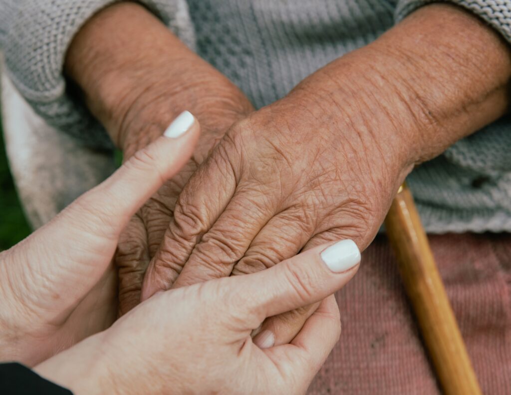 a caregiver and client hold hands