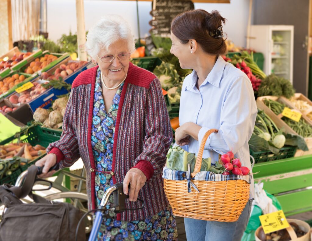 an elderly women goes grocery shopping with their caregiver