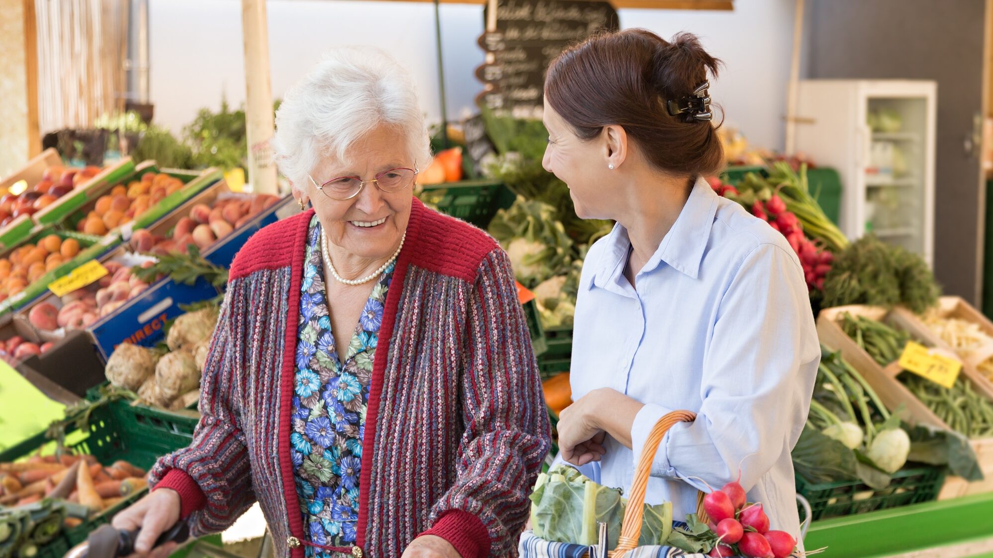 an elderly women goes grocery shopping with their caregiver
