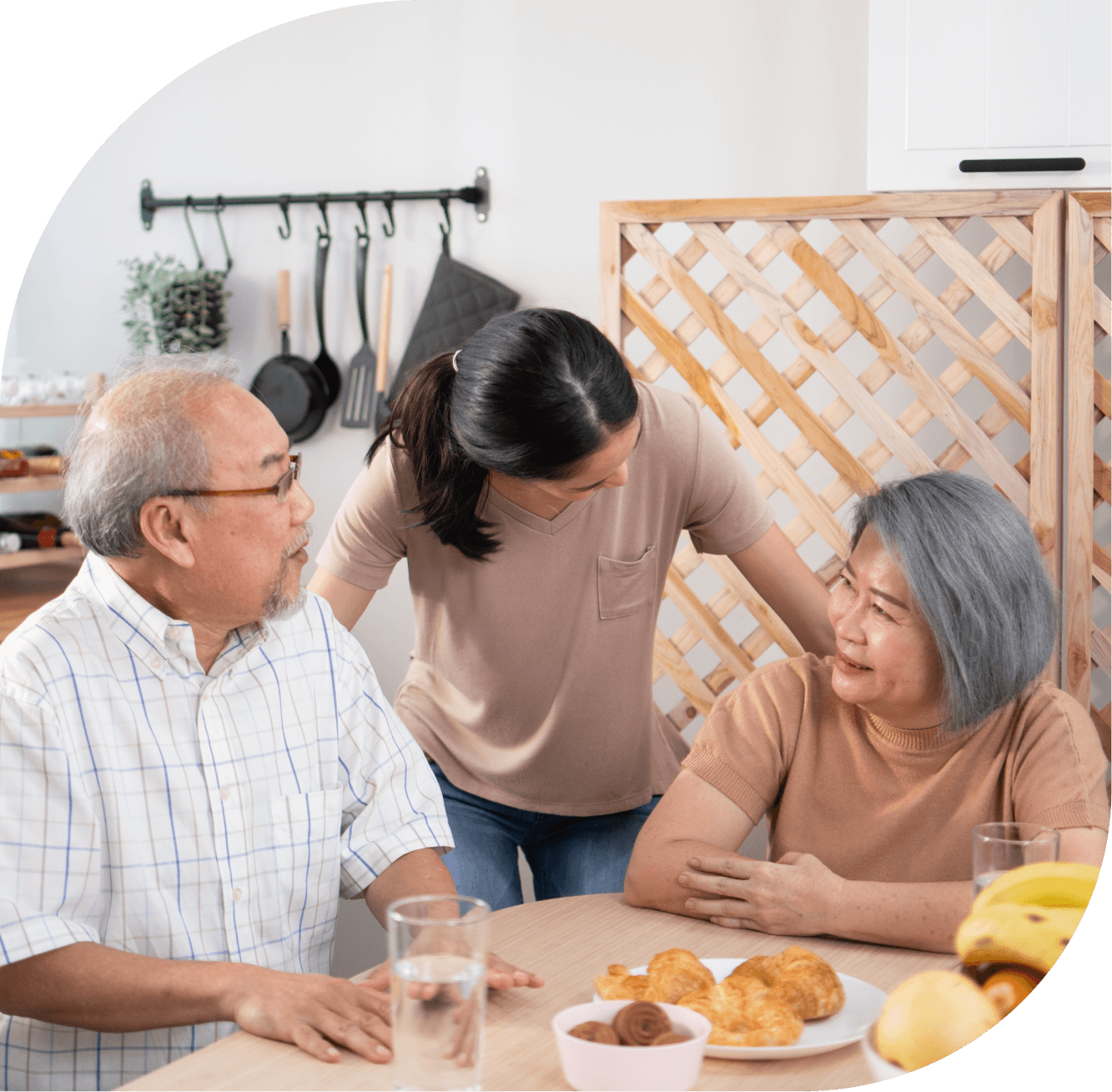 mature couple and young woman in kitchen at breakfast table
