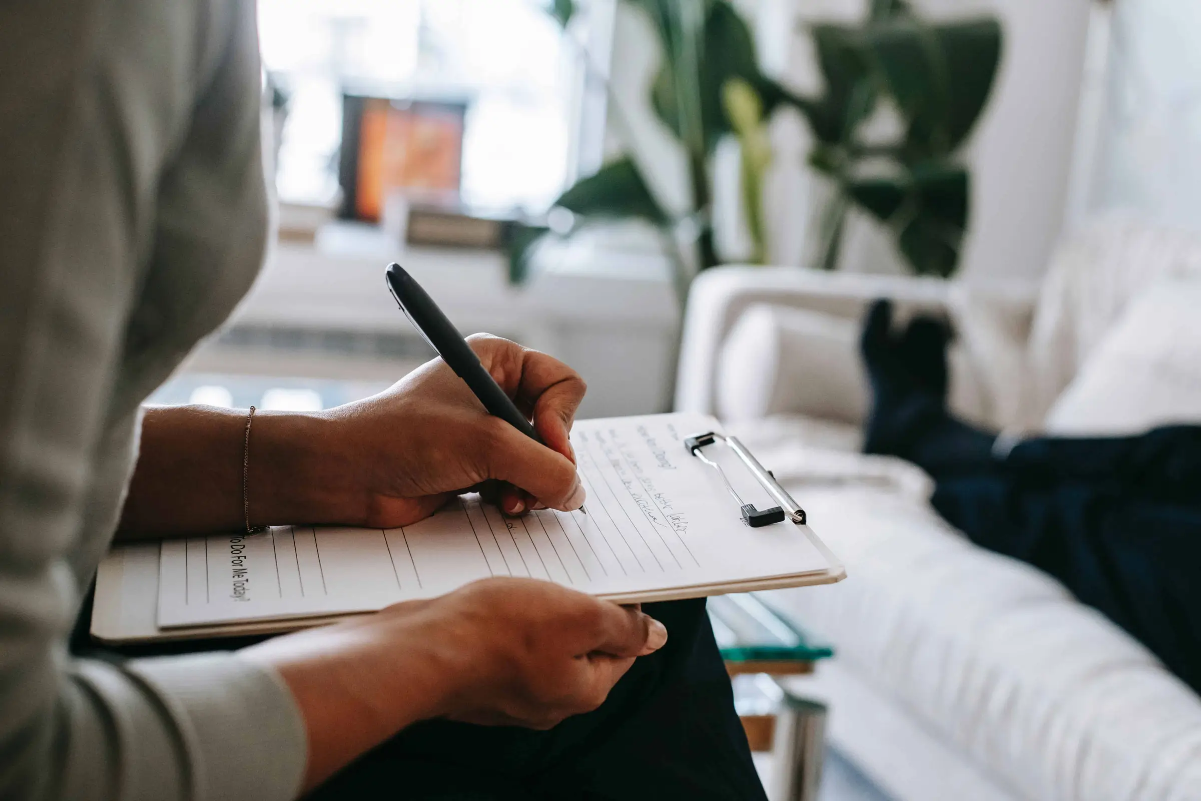 a person is taking notes on her notepad, resembling a free home care assessment