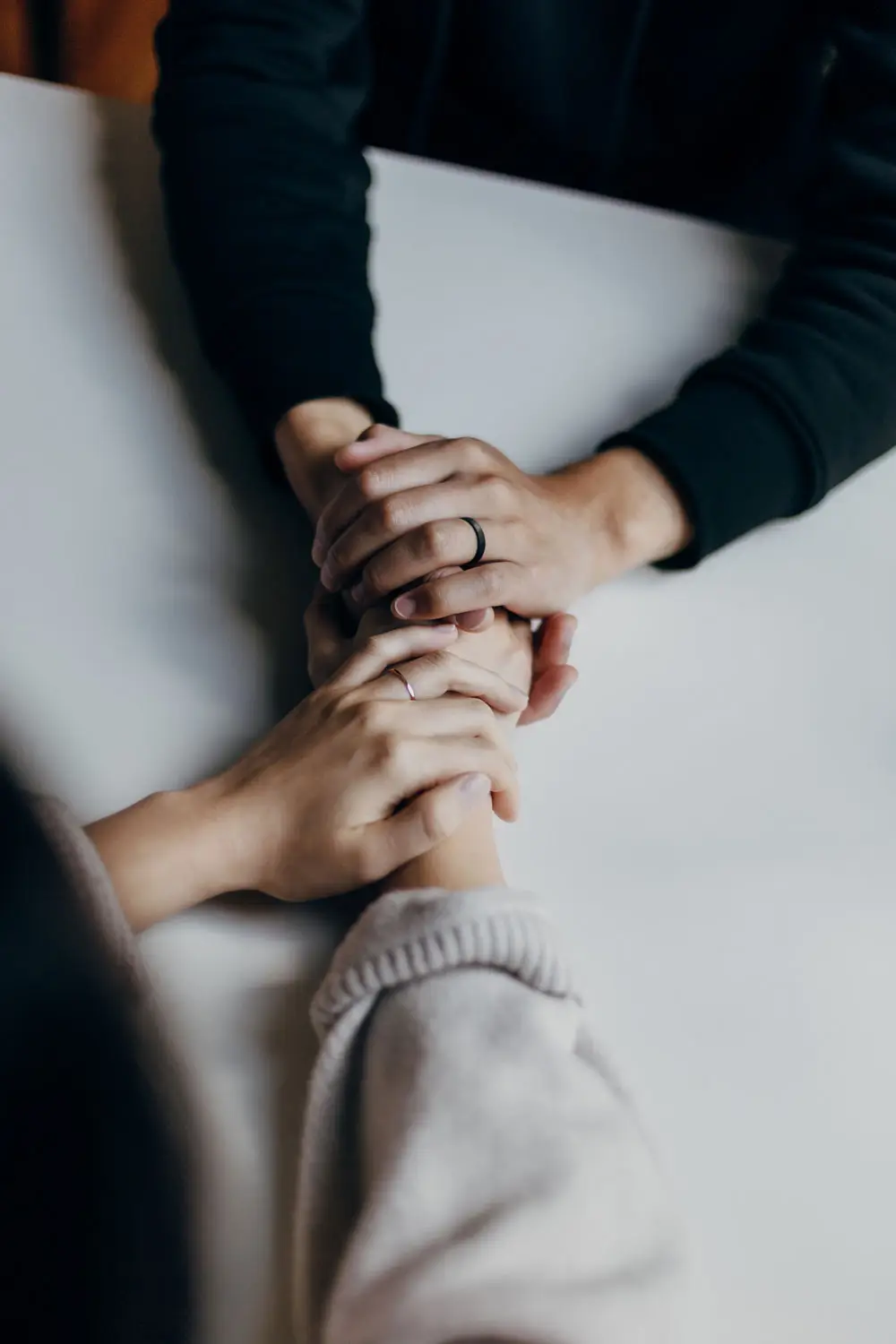close up of two people holding hands across a table